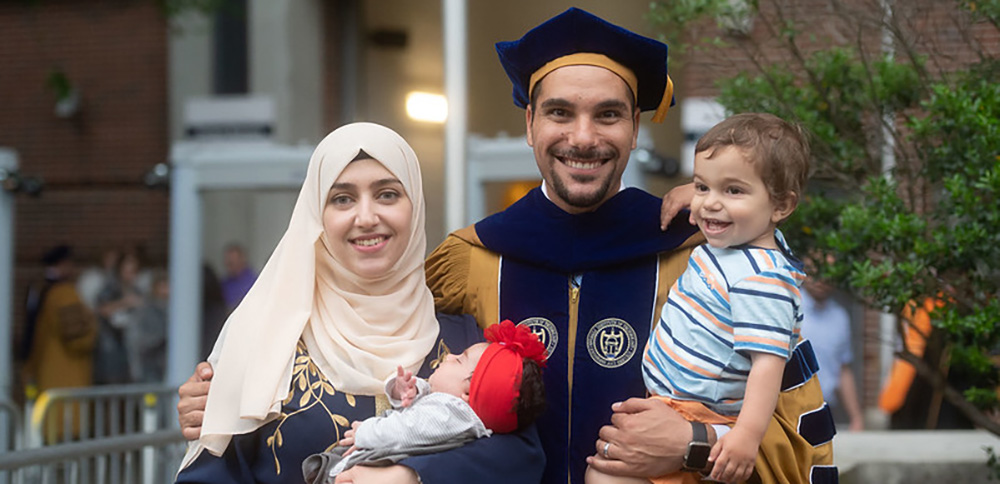 A Ph.D. graduate with their family at commencement